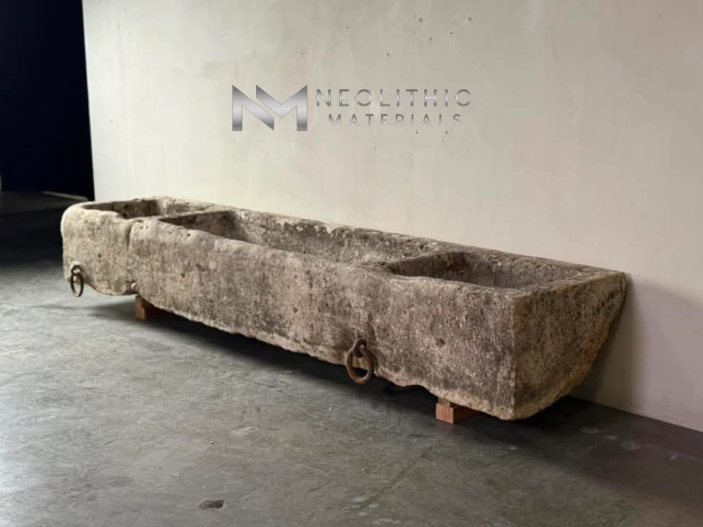 Trough FG103-58.OM.79x17x11 viewed from a high overhead angle, highlighting the depth of the carved stone compartments and the rustic iron rings attached to the weathered front profile