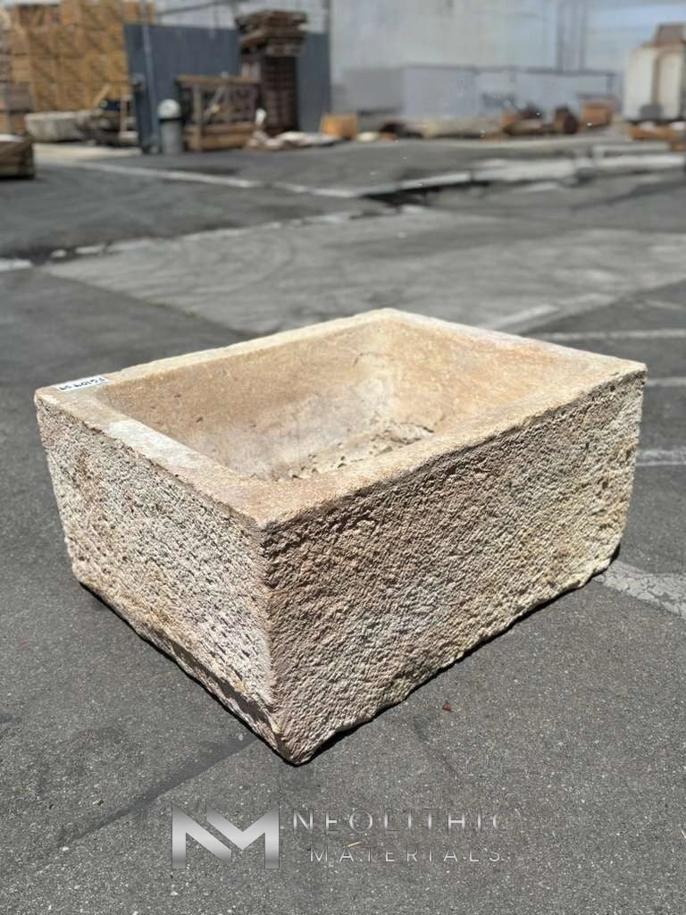 Trough FG104-04.MT to FG104-17.MT rectangular weathered stone basin featuring highly textured chiseled exterior walls captured from a high side angle in an outdoor lot.