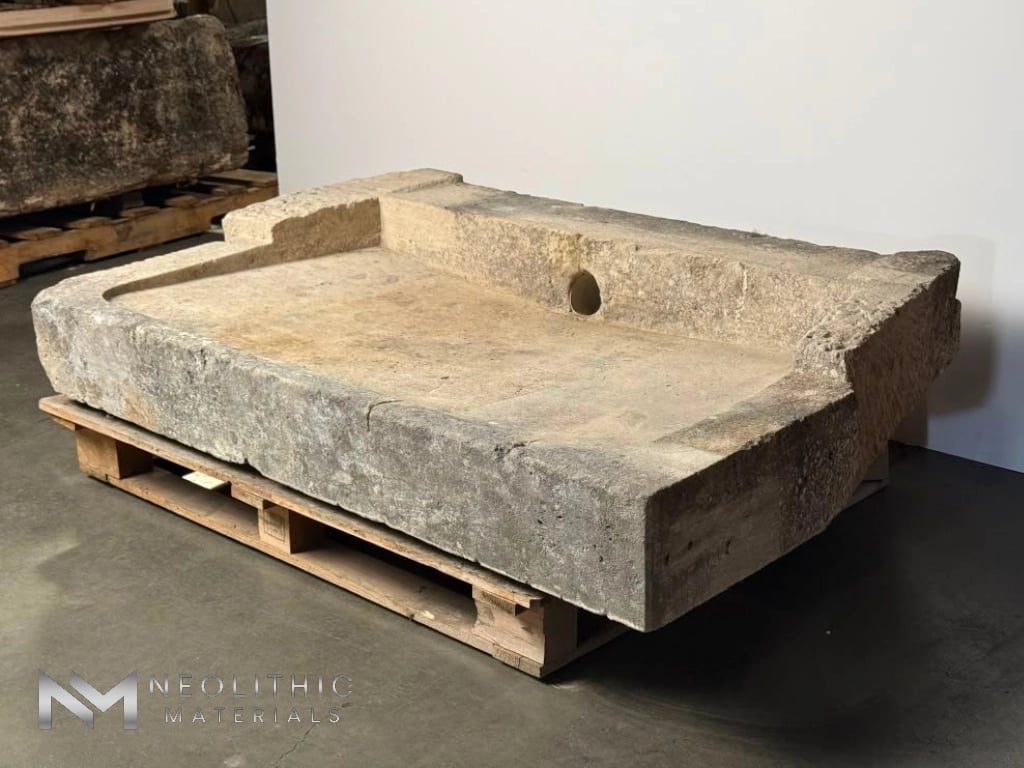 Trough FG104-20.56x39x11 three-quarter studio catalog view showcasing an exceptionally thick, rustic rectangular stone slab trough with a recessed center basin, displayed on a wooden shipping pallet against a white backdrop.