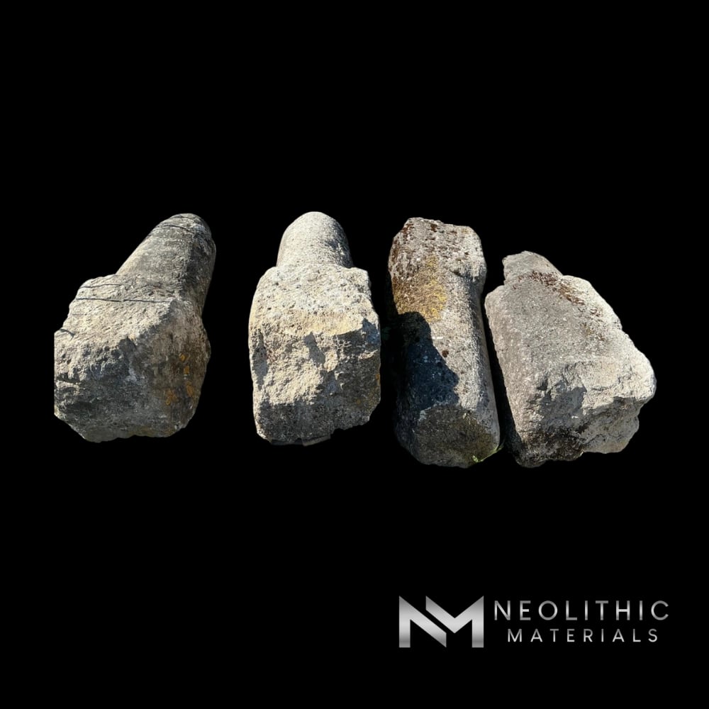 Miscellaneous FG105-08 to FG105-11 ancient hand-carved limestone blocks and rustic structural pillars displaying aged dark patina arranged outside on pallets.