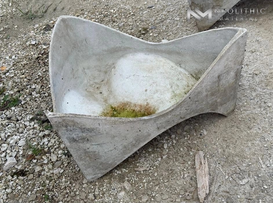 Planter FK104-03 mid-century style abstract stone molar planter vessel with curved pointed corners and aged organic texture shown from a high side angle.